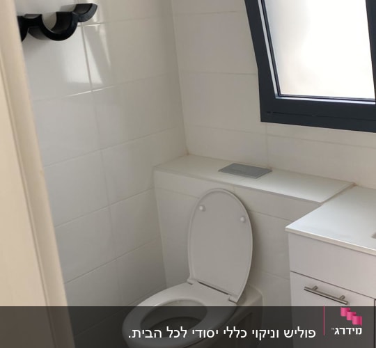 שירותים נקיים עם אסלה פתוחה וקיר אריחים לבן
